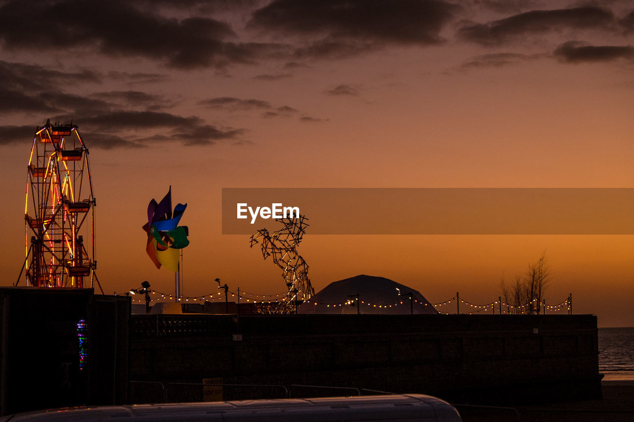 FERRIS WHEEL AGAINST SKY AT DUSK