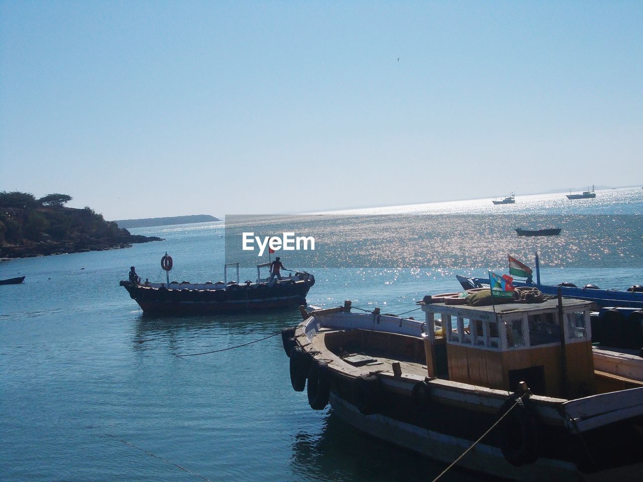 Boats in sea against clear sky