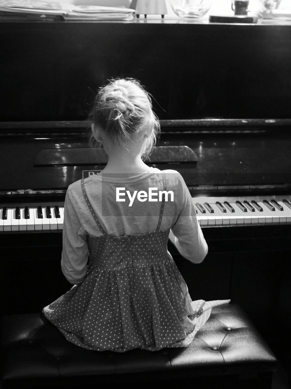 Rear view of girl playing piano