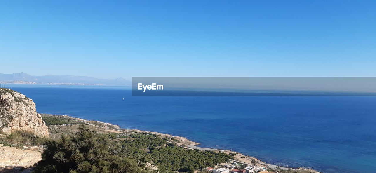 Scenic view of sea against clear blue sky