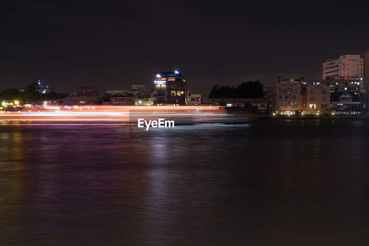 ILLUMINATED CITY AT WATERFRONT