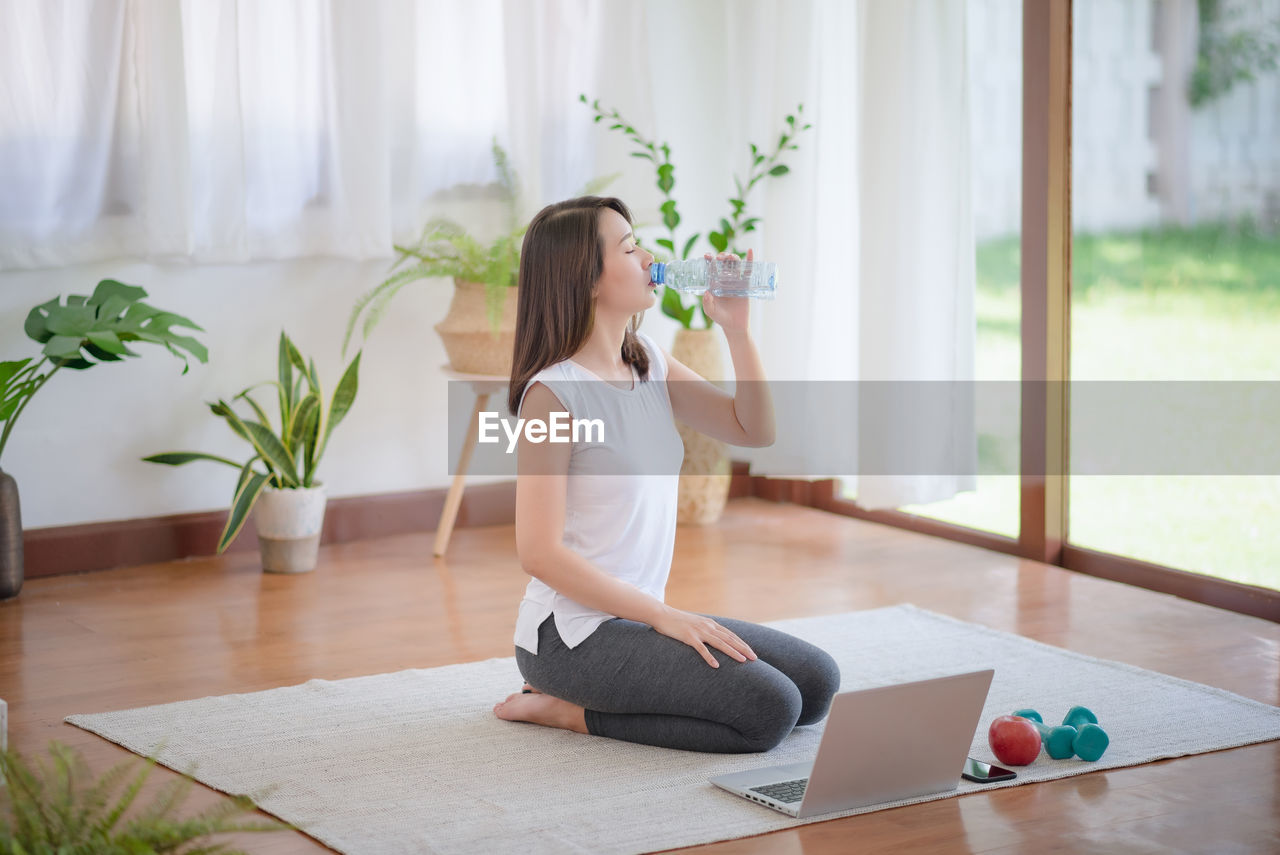 Beautiful asian woman staying fit by exercising at home for healthy trend lifestyle