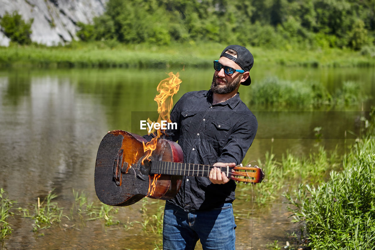 Man playing guitar in lake