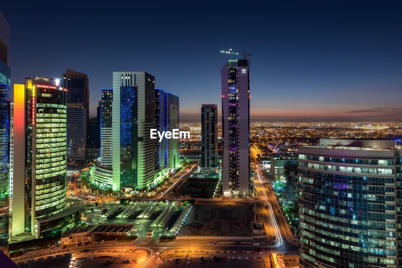 Illuminated cityscape against sky at night