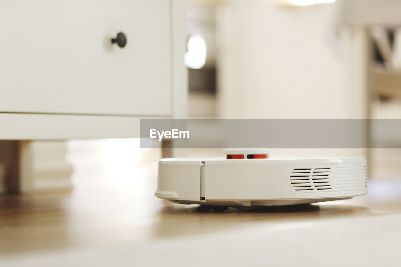 White robotic vacuum cleaner. the robot is controlled by voice commands for direct cleaning. modern 