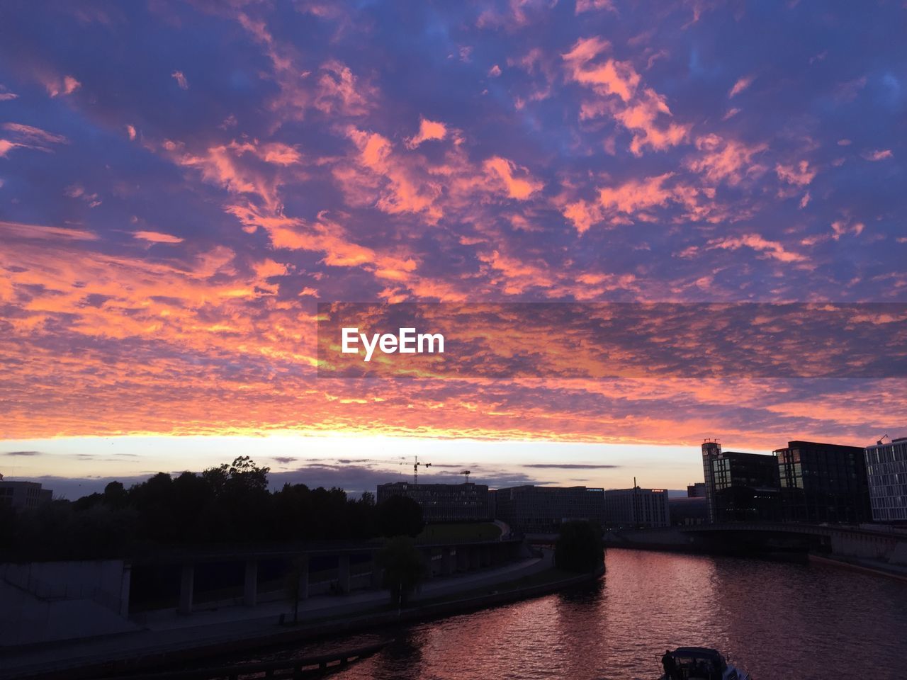 Silhouette of built structure against cloudy sky at sunset