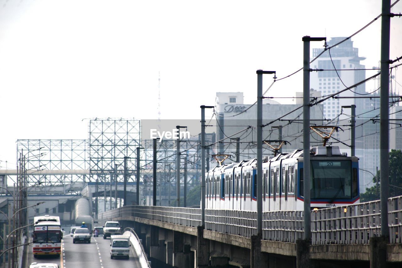 Train on railroad track by road against clear sky