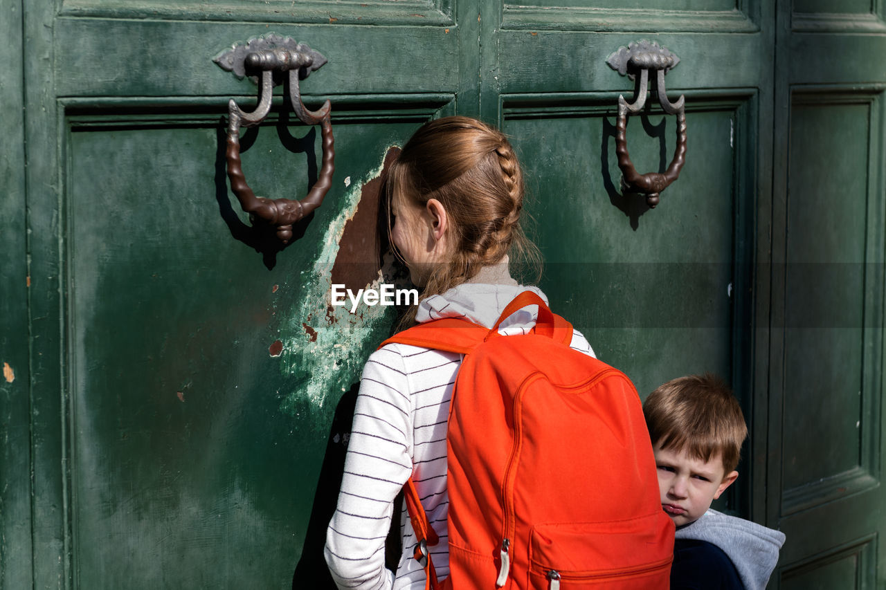 Rear view of a boy looking through door