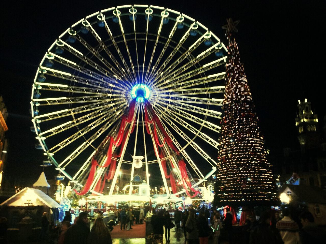 LOW ANGLE VIEW OF ILLUMINATED FERRIS WHEEL AT NIGHT