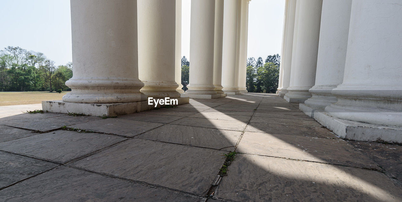 architectural column, column, architecture, built structure, day, history, the past, no people, nature, colonnade, outdoors, building exterior, government, sunlight, city, travel destinations, plant, marble, memorial, travel, politics and government, flooring
