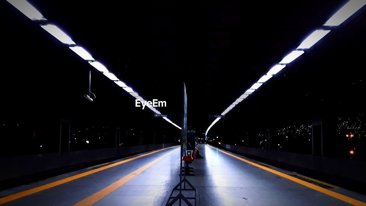 Illuminated railroad station platform at night