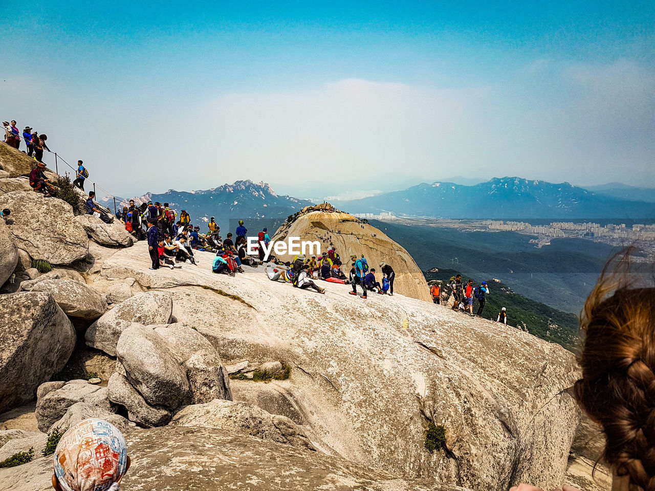 People on cliff against sky