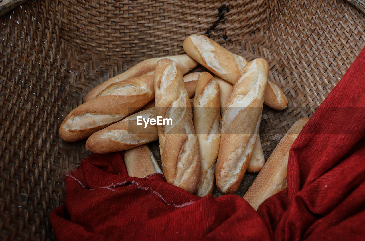 High angle view of baguettes with red fabric in wicker basket