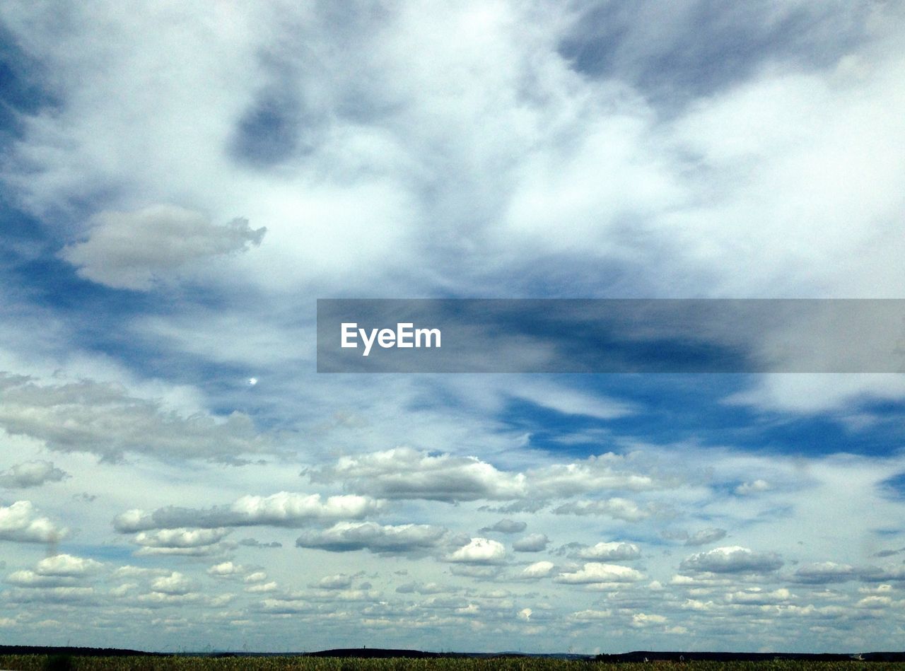 Countryside landscape below blue sky and clouds