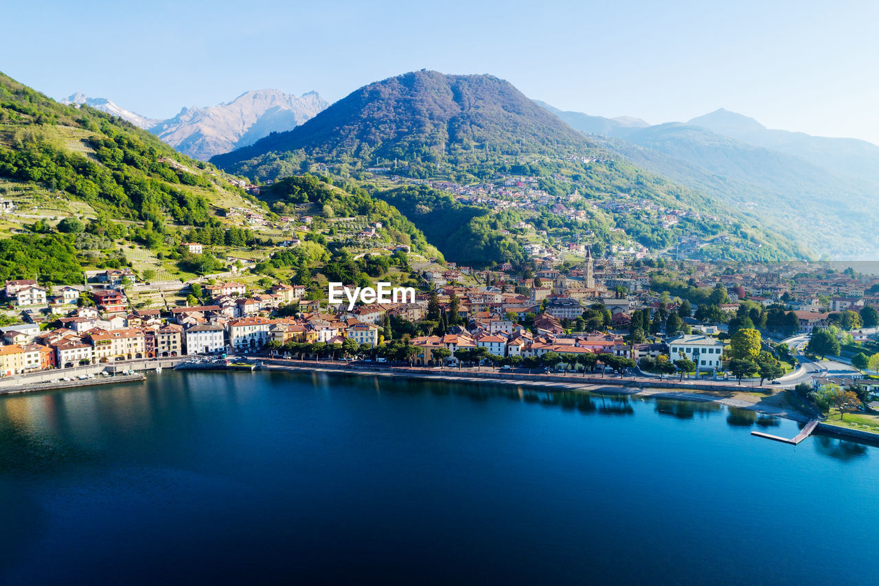 SCENIC VIEW OF TOWN BY MOUNTAINS AGAINST SKY