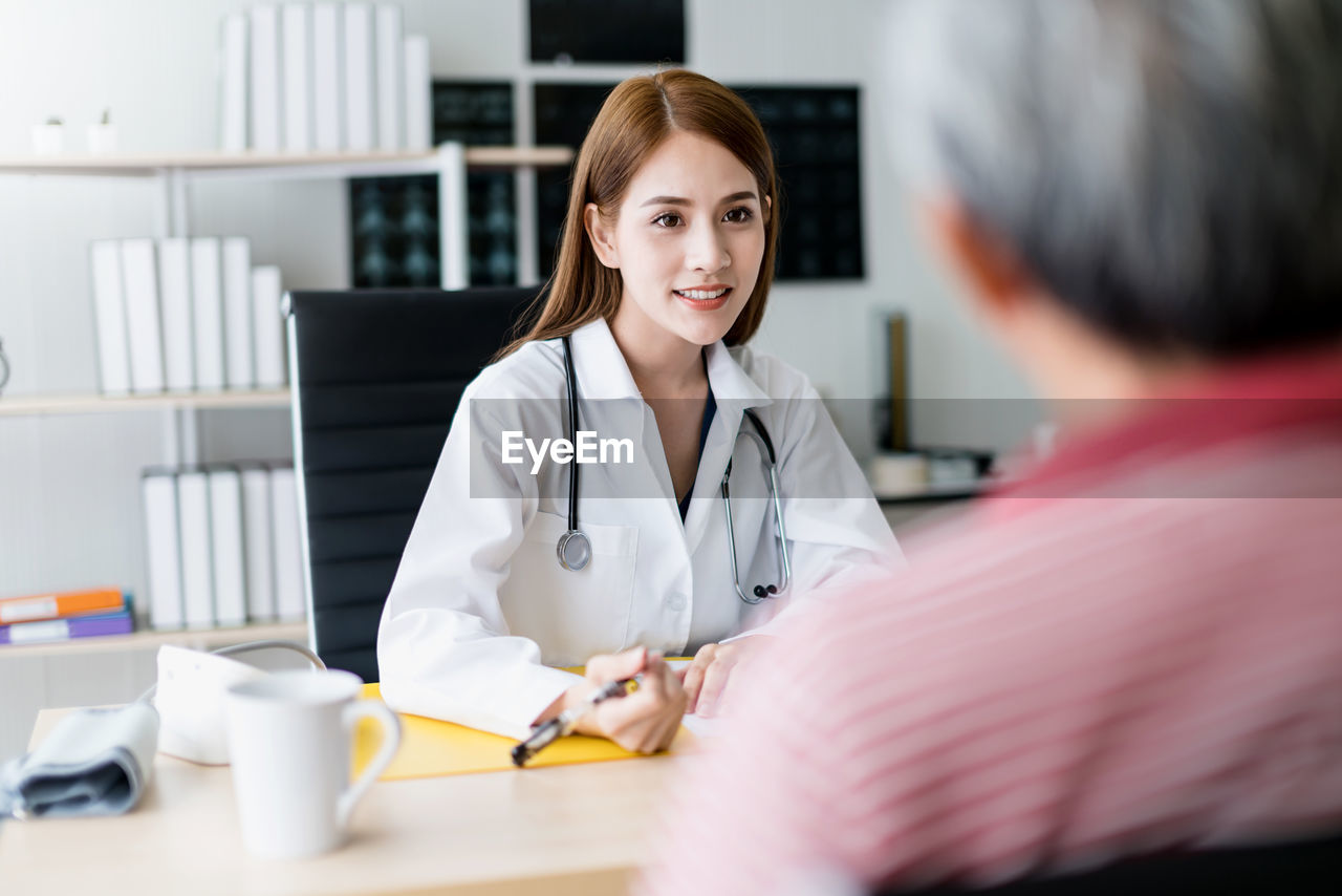 Female doctor talking with patient in hospital