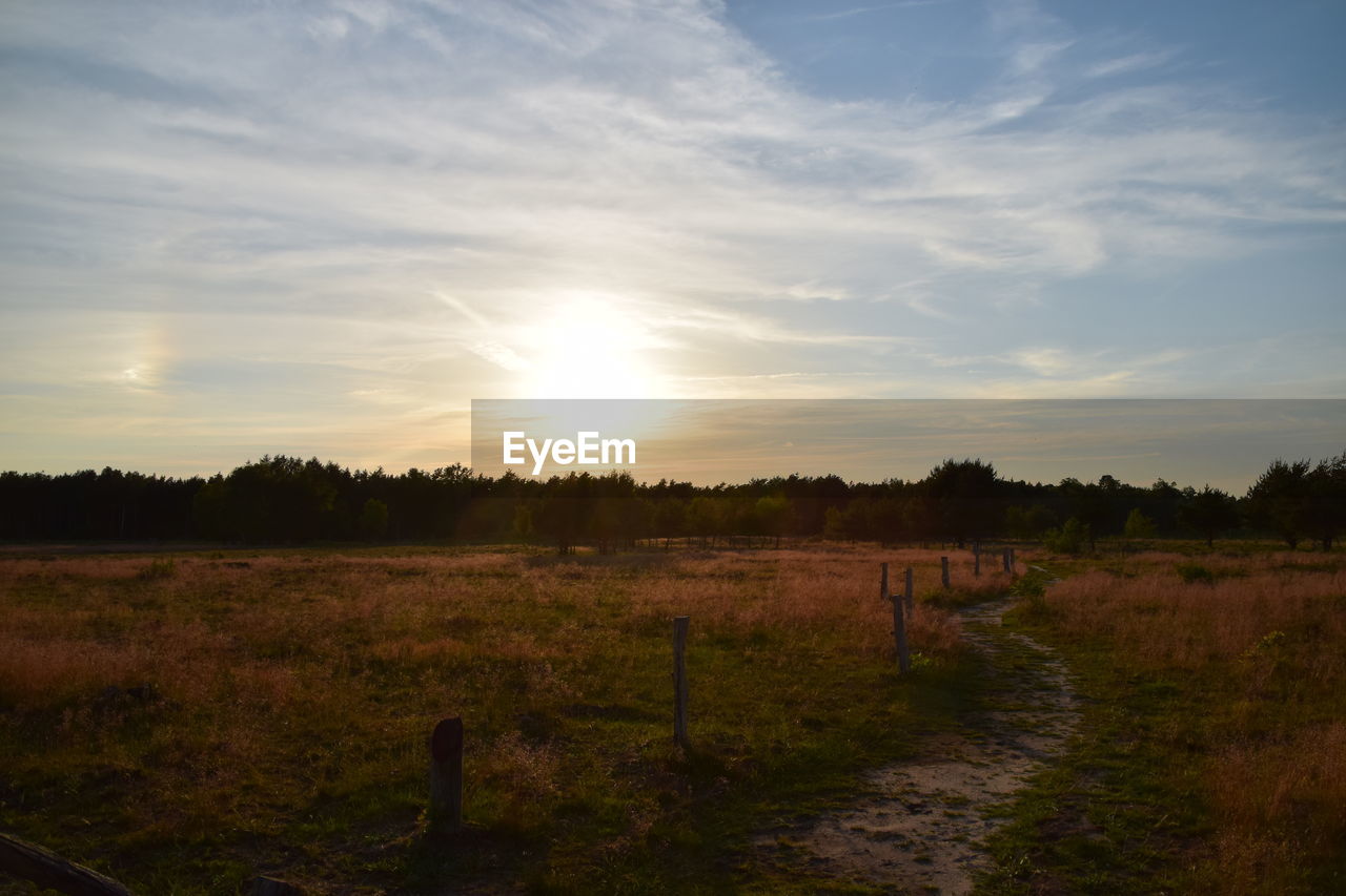 SCENIC VIEW OF FARM AGAINST SKY DURING SUNSET