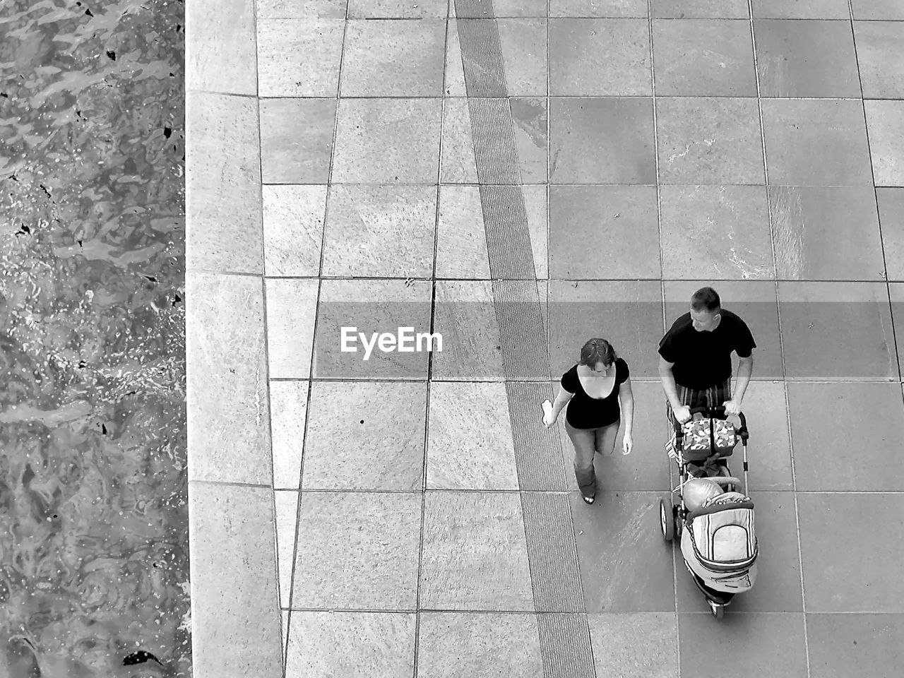 HIGH ANGLE VIEW OF PEOPLE WALKING ON COBBLESTONE STREET