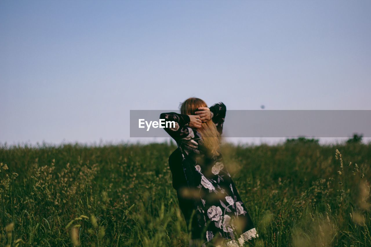 Woman standing on grassy field