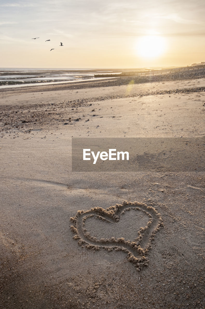 Scenic view of beach against sky during sunset