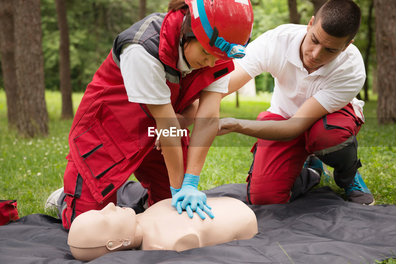 Healthcare workers practicing on cpr dummy at park