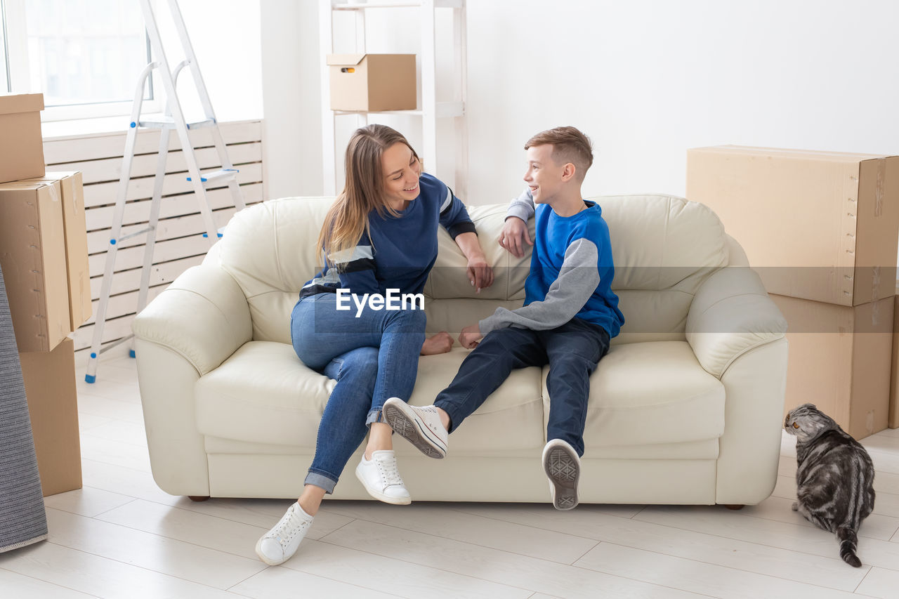 WOMEN SITTING ON SOFA AT HOME