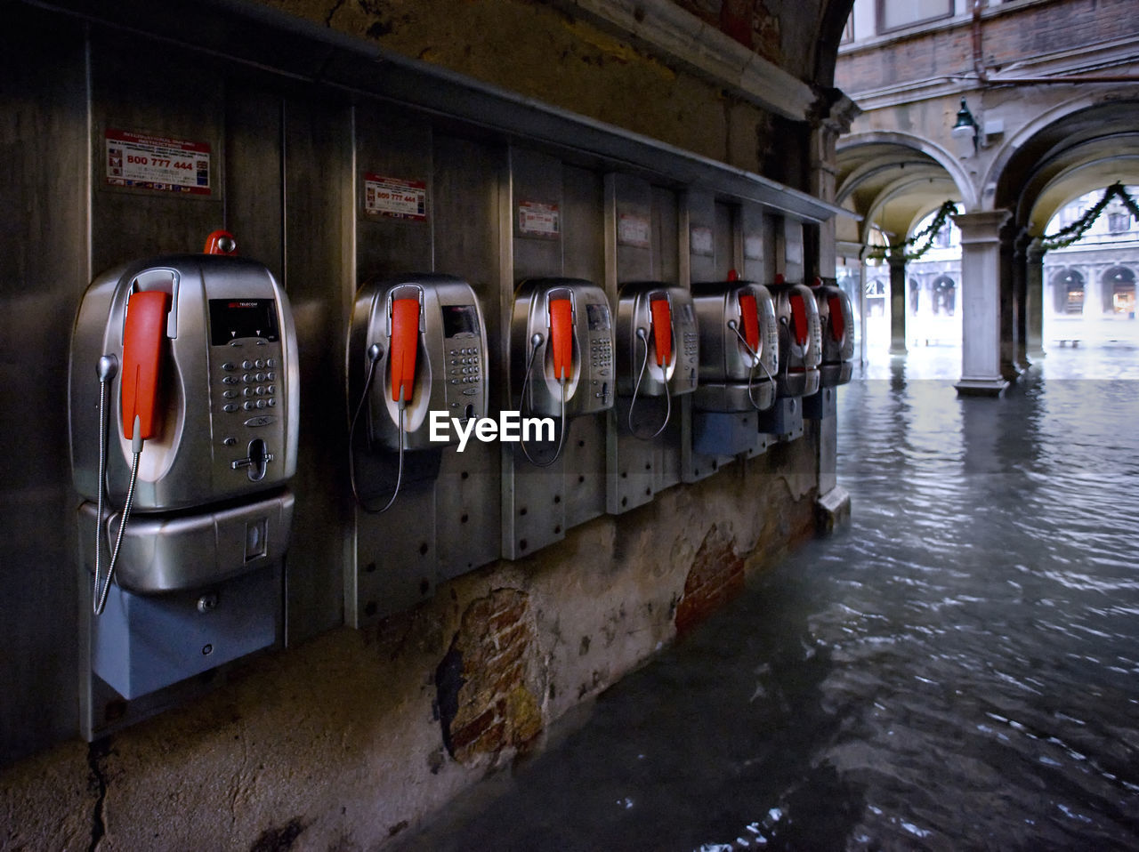 Pay phones on wall by water filled walkway during flood at st marks square