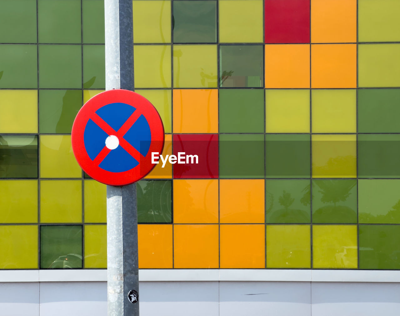 yellow, multi colored, circle, geometric shape, no people, shape, sign, line, art, architecture, wall - building feature, traffic sign, communication, wall, green, number, transportation, day, red, outdoors, built structure, pattern, window