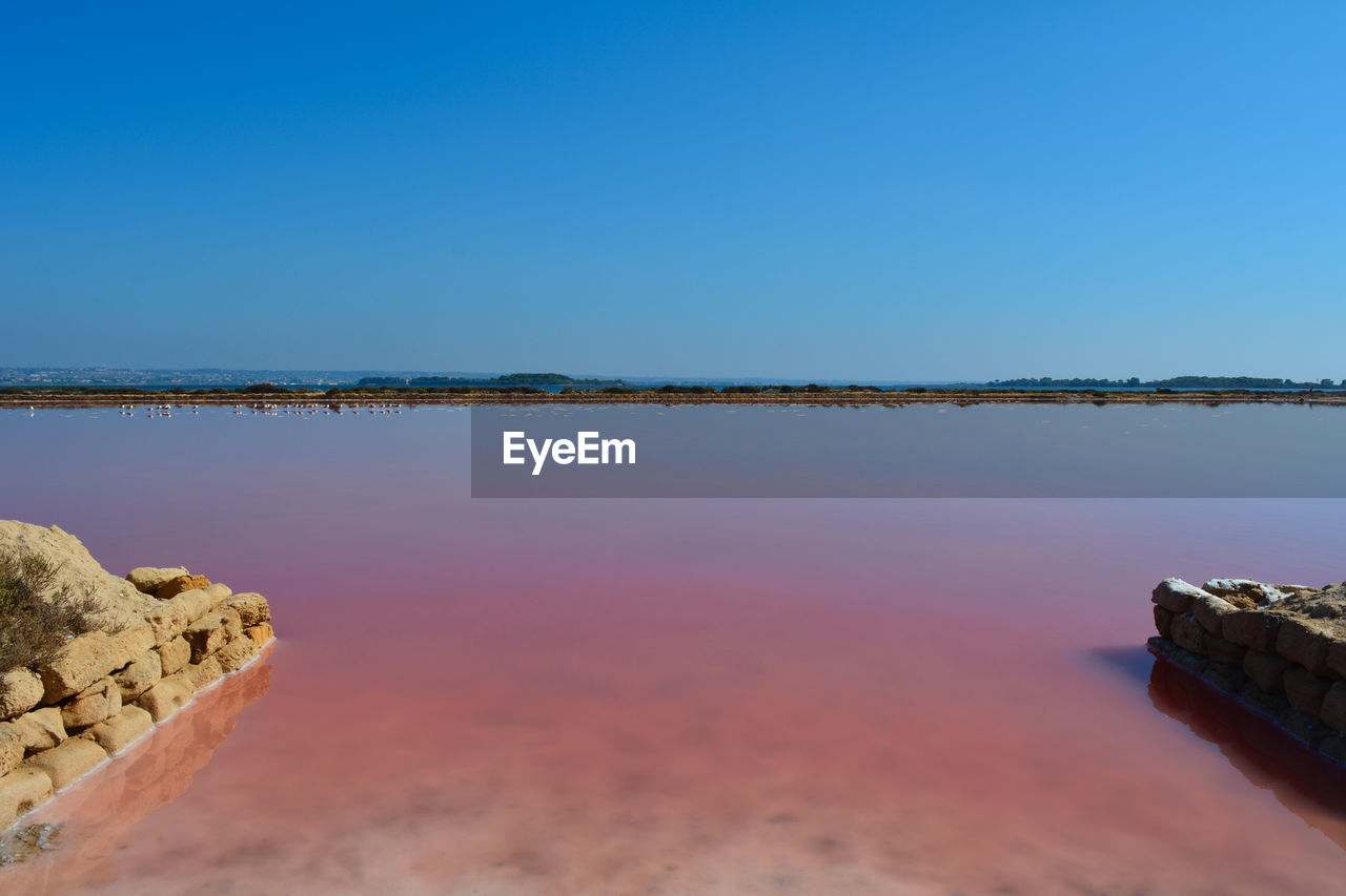 Scenic view of sea against clear blue sky