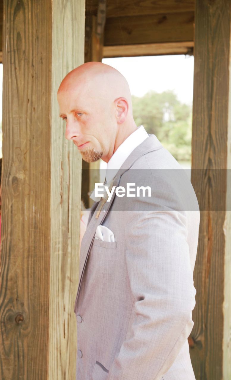 Side view of businessman looking away inside wooden building