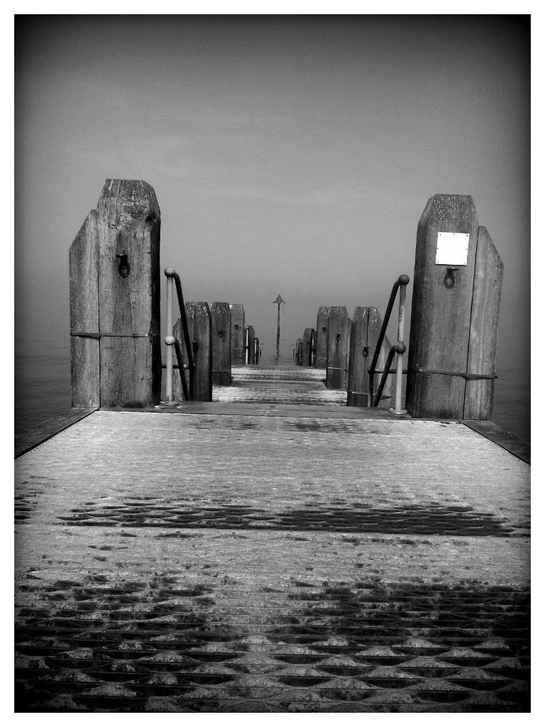 Pier on sea against sky at dusk