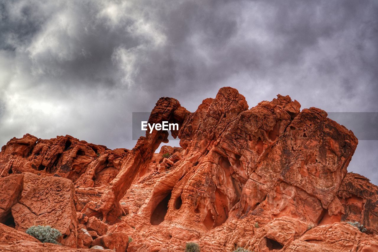 Low angle view of rock formation against cloudy sky