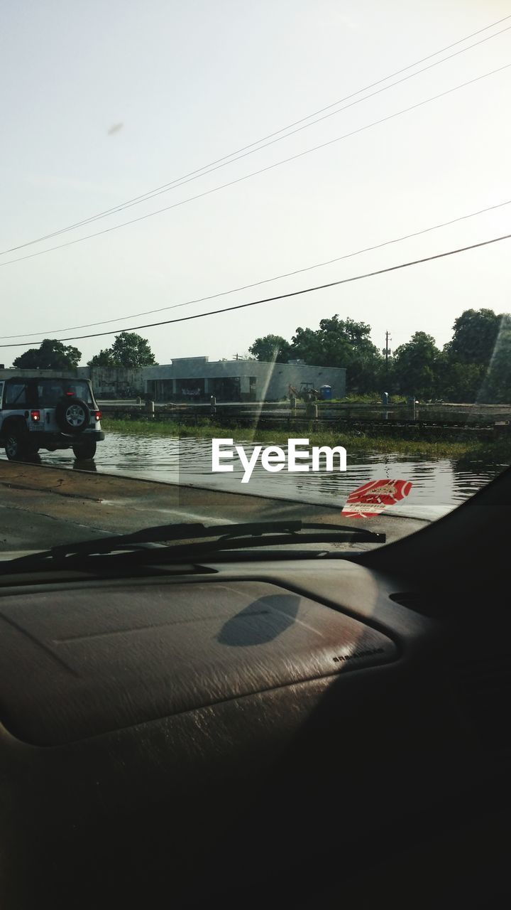 Car on wet street seen through windshield