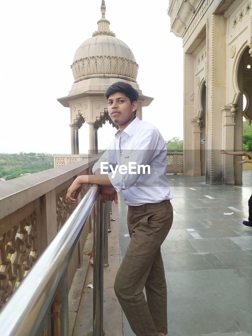 PORTRAIT OF YOUNG MAN STANDING AGAINST BUILDING