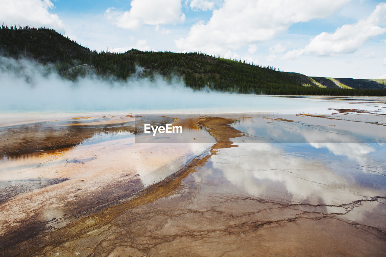 Scenic view of hot springs at yellowstone national park against cloudy sky