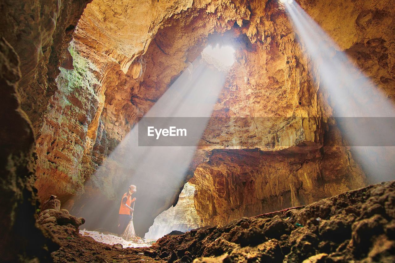 Mid adult man cleaning in cave