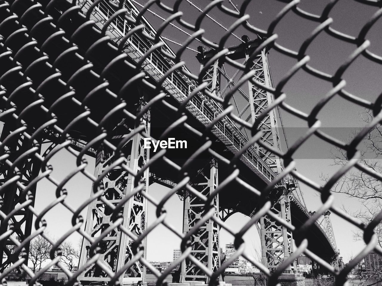 Low angle view of bridge through chainlink fence