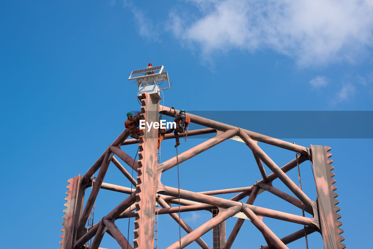 LOW ANGLE VIEW OF METALLIC STRUCTURE AGAINST BLUE SKY