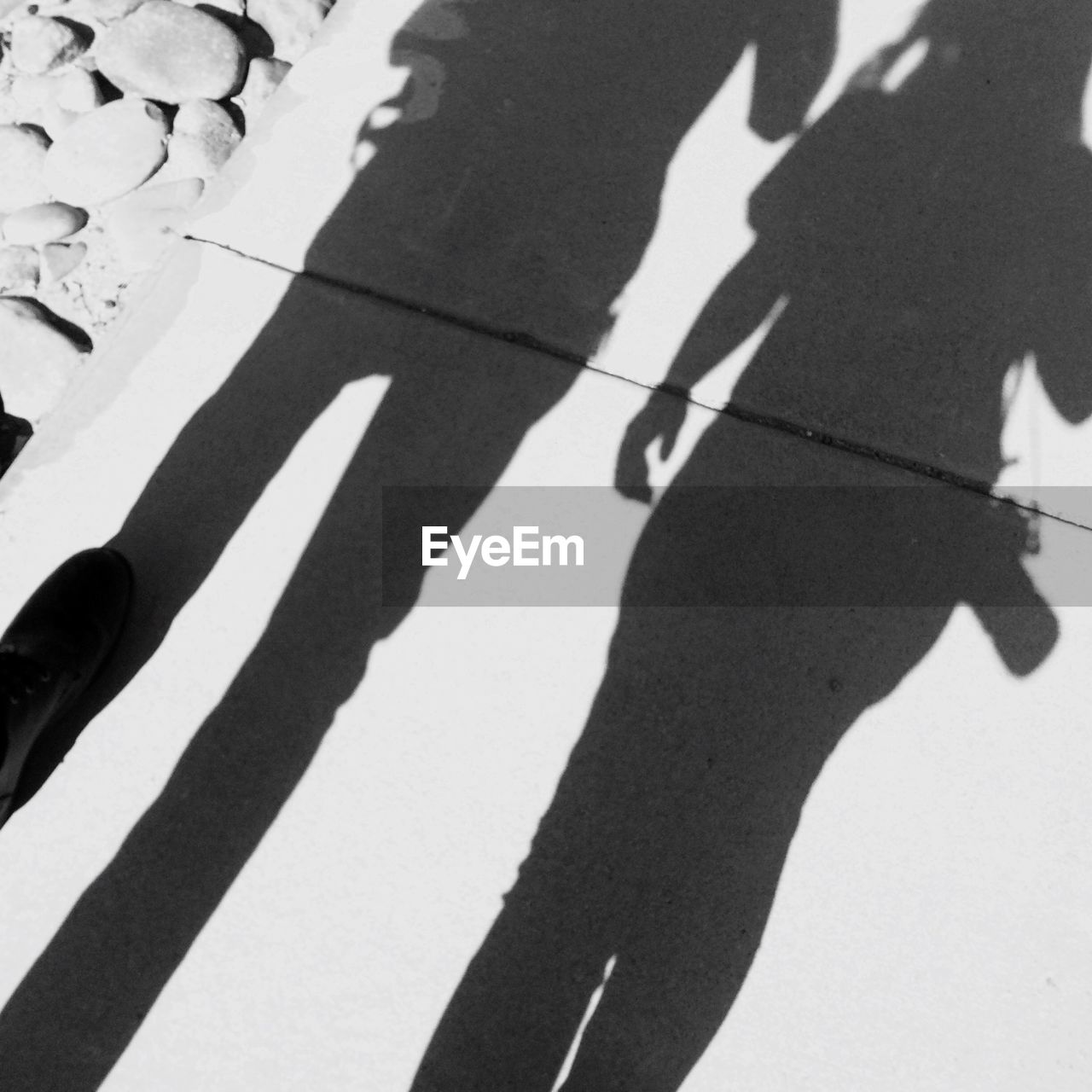 LOW SECTION OF PEOPLE STANDING ON SHADOW OF MAN