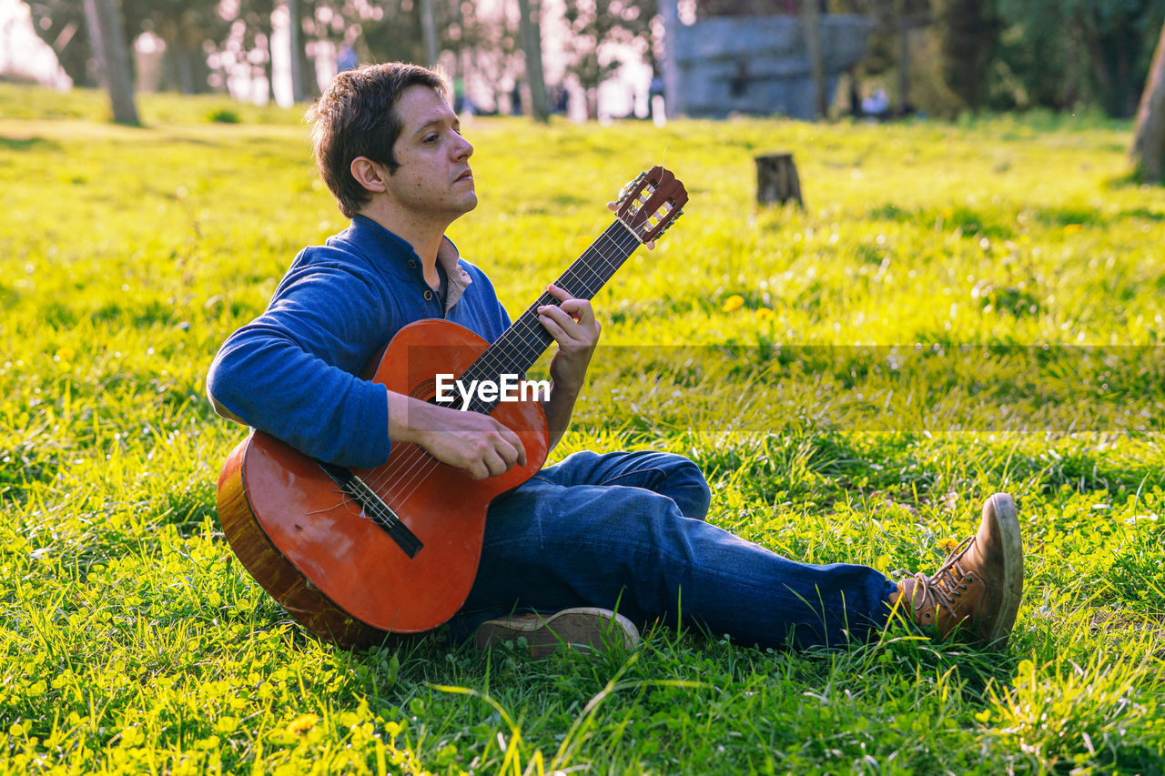 Man playing guitar on field