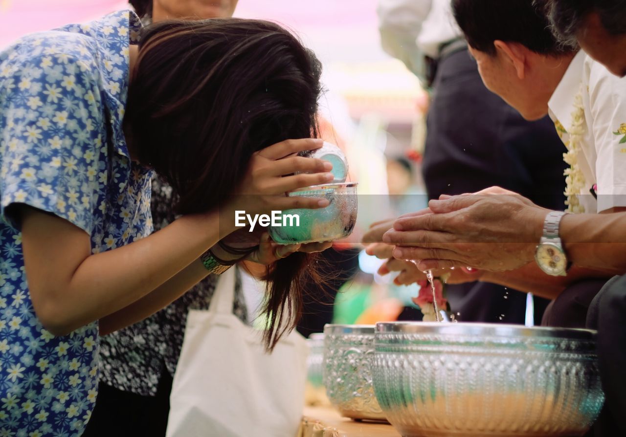 Woman with bowl by person and container