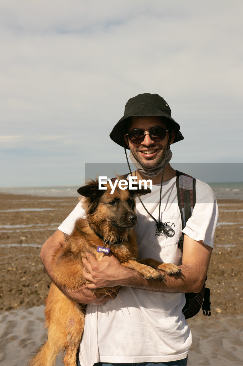 MAN WITH DOG ON SHORE