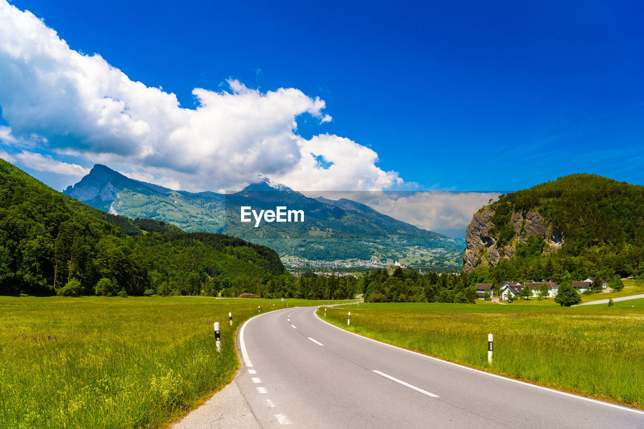 ROAD BY MOUNTAINS AGAINST SKY