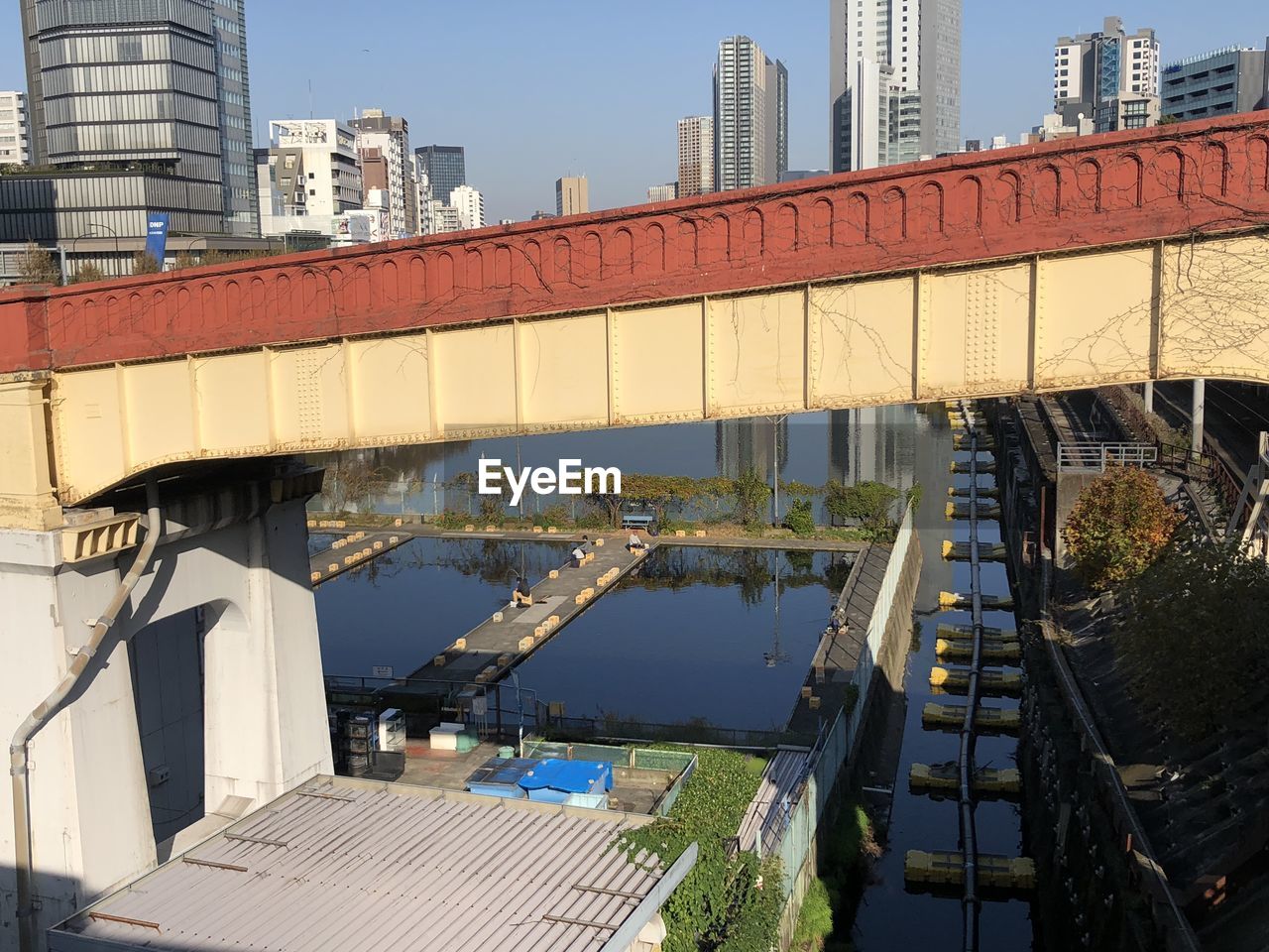 HIGH ANGLE VIEW OF BRIDGE OVER RIVER AMIDST BUILDINGS