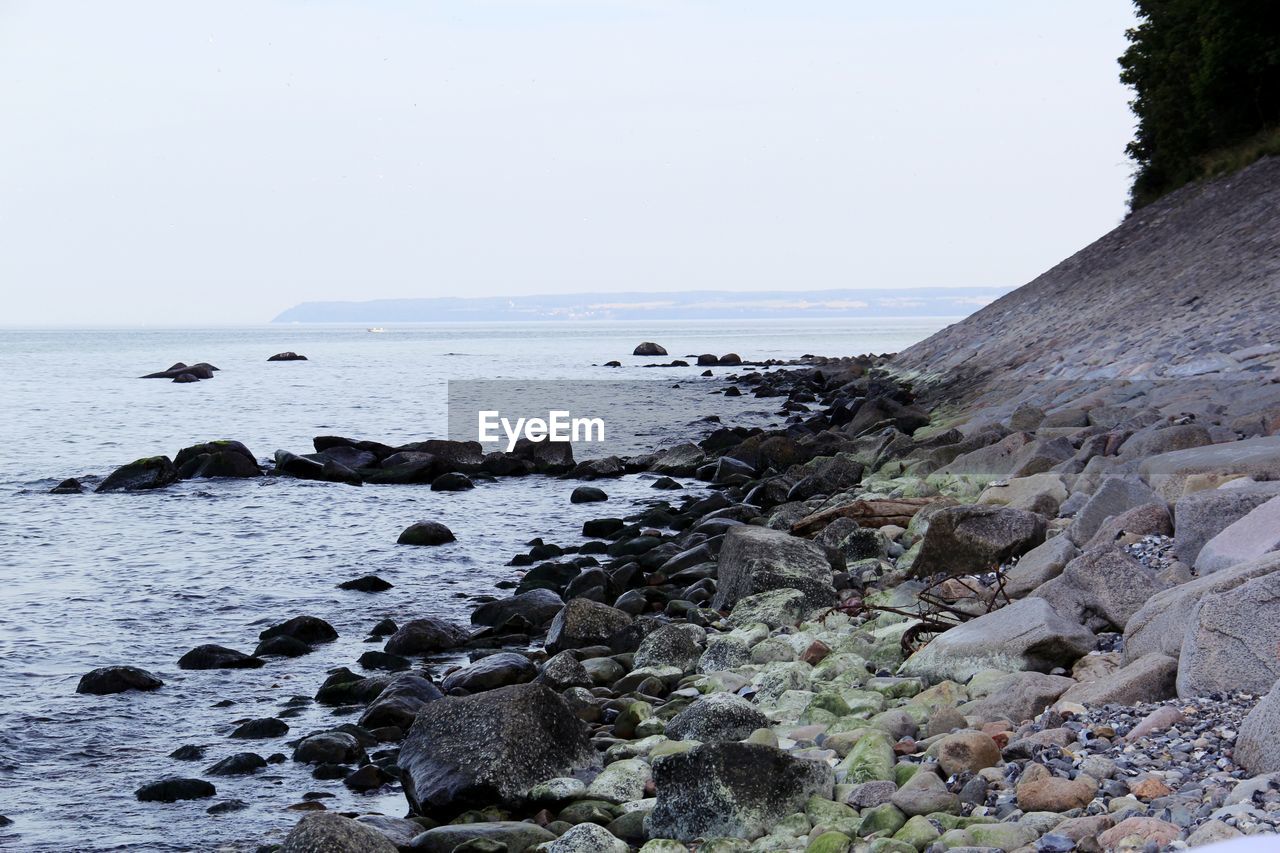 Rocky shore against clear sky