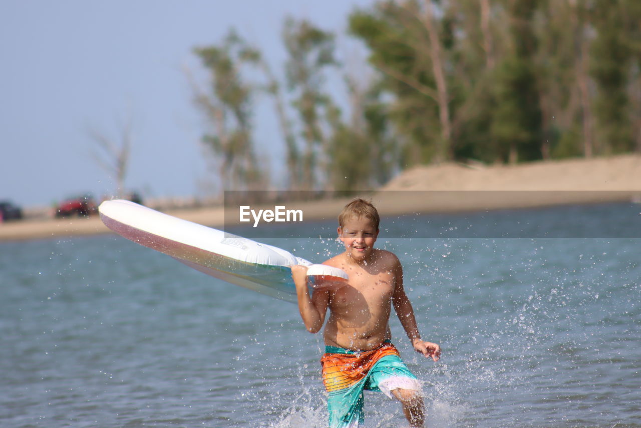 Full length of shirtless boy in water