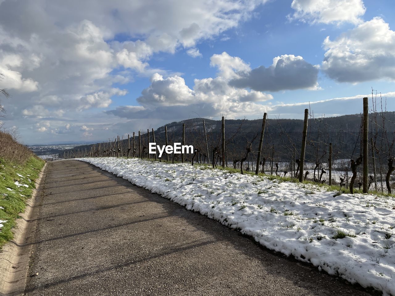 sky, cloud, nature, landscape, environment, no people, land, fence, scenics - nature, day, plant, beauty in nature, road, outdoors, mountain, footpath, walkway, security, protection, horizon, transportation, the way forward, tranquility, sunlight, architecture, snow