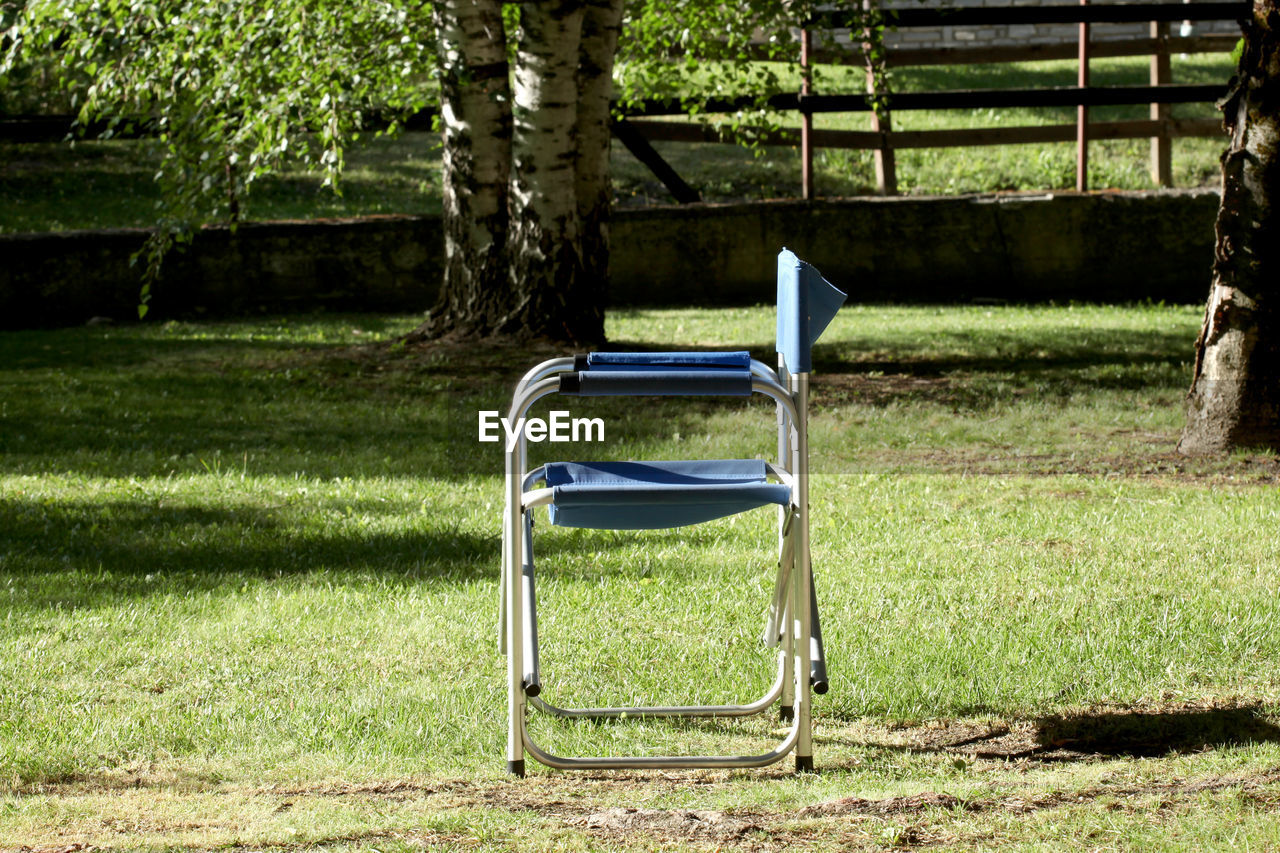 EMPTY BENCH IN FIELD