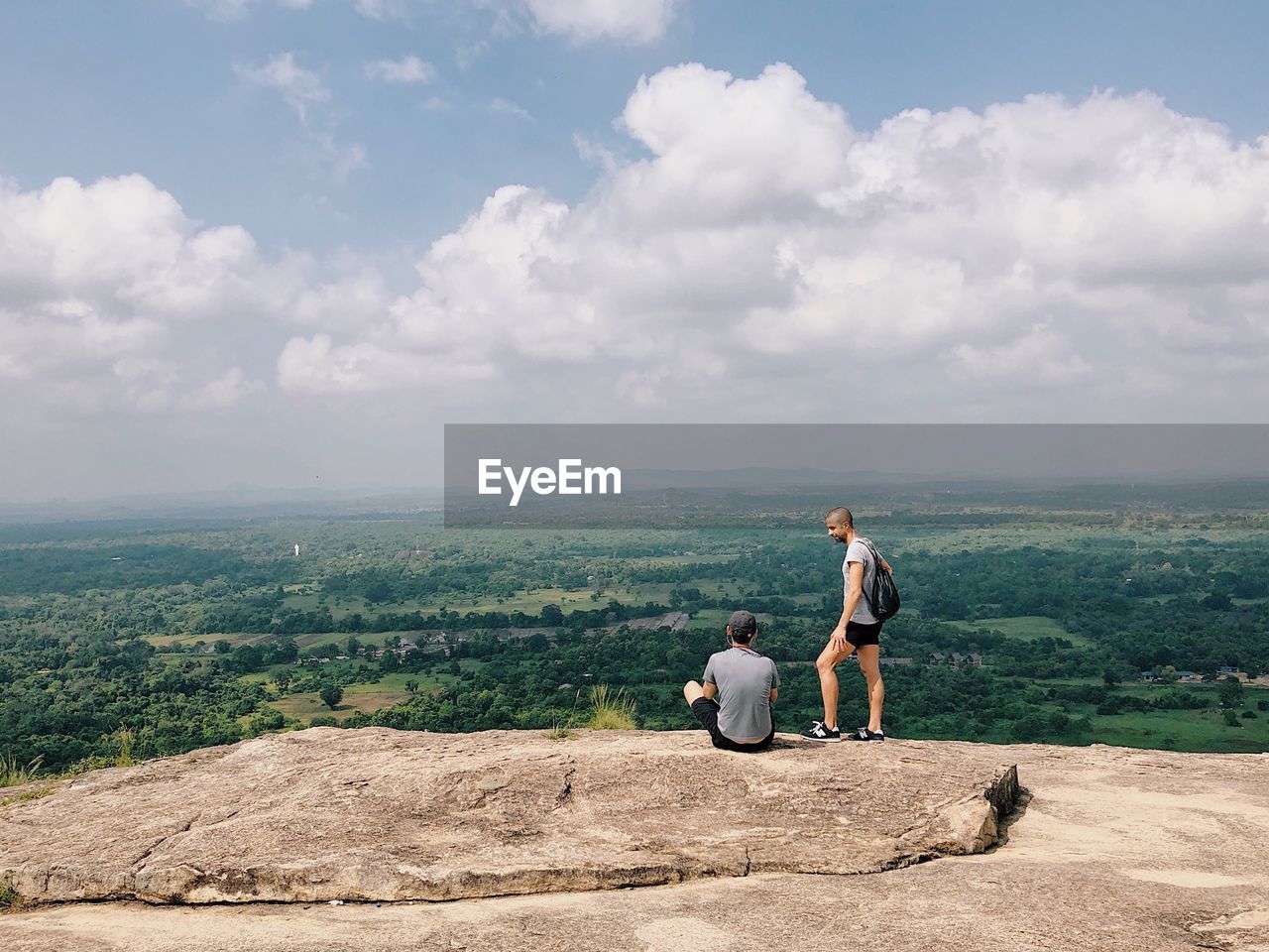 FULL LENGTH OF FATHER AND SON SITTING ON MOUNTAIN