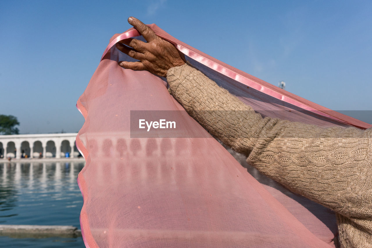 Close-up of woman lifting pink fabric